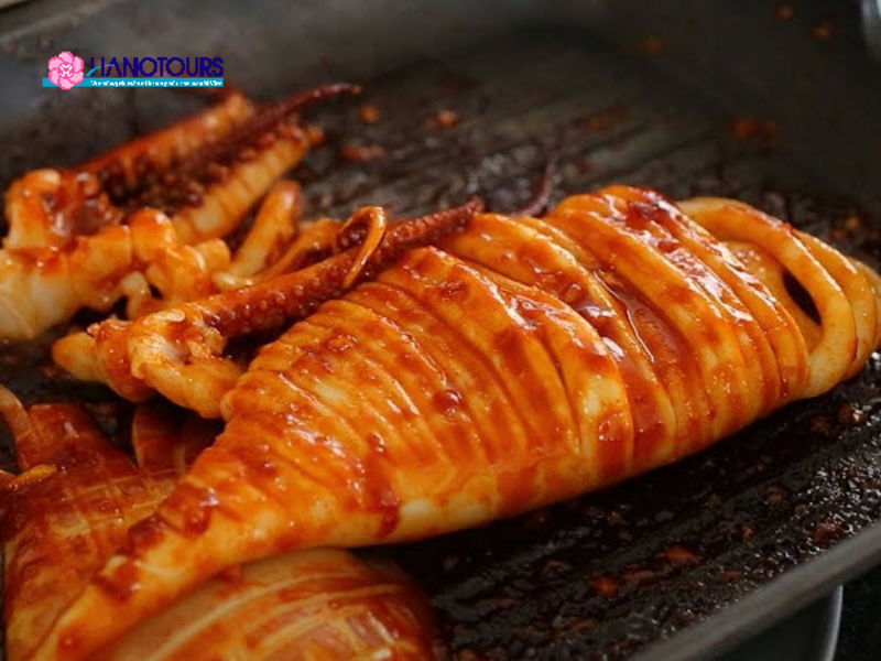 Mực nướng được nướng chín và ăn cùng với salad trộn và nước sốt chấm